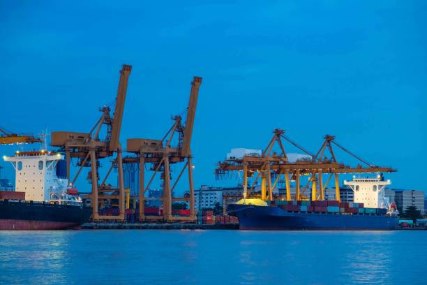 istock Container loading by crane, cargo ship at shipping port at twilight, Logistics and transportation concept 840053270