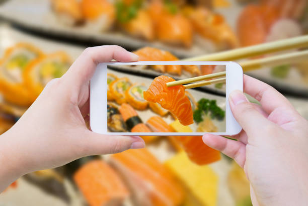 istock Taking photo of salmon sashimi in chopsticks 840060930