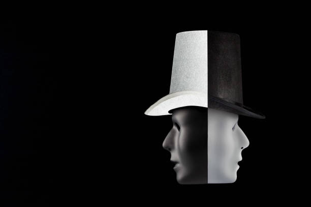 istock Black and white masks wearing top hat looking in opposite directions isolated on black background with copy space. Double talk and hypocricy concept 840061740
