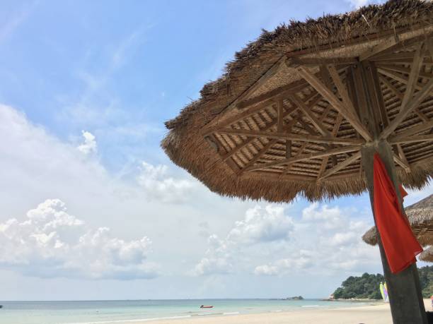 istock Straw parasol with red dress hanging on a beautiful beach 840067452