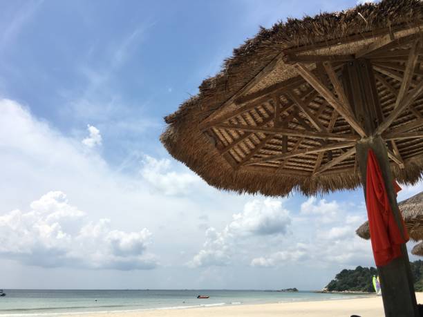 istock Straw parasol with red dress hanging on a beautiful beach 840067498