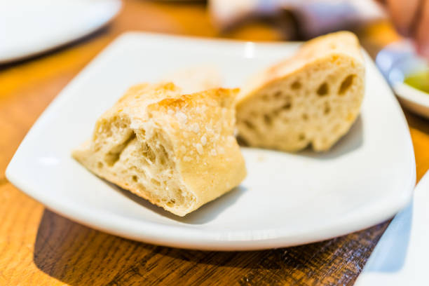 istock Macro closeup of fresh baguette bread slices on plate in restaurant table 840068198