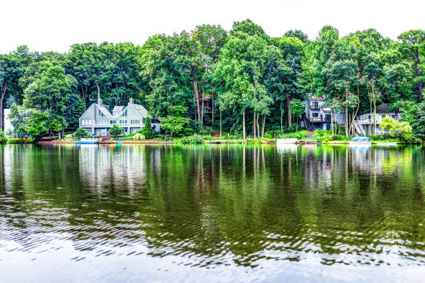 Lake Audubon with lakefront waterfront houses in Reston, Virginia with reflection of summer green foliage on trees