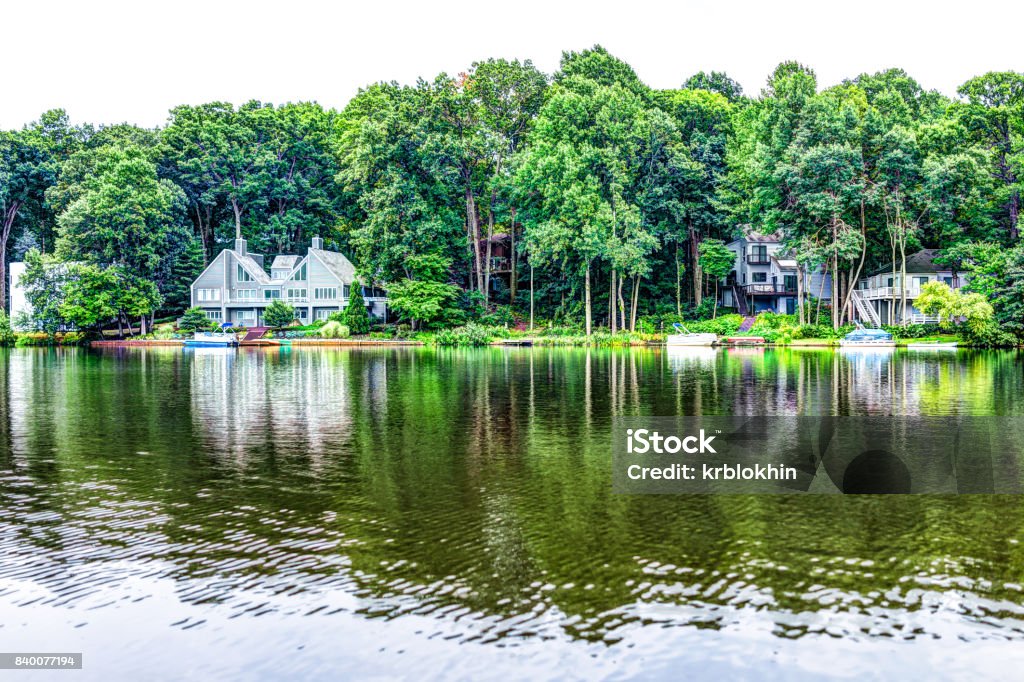 Lake Audubon with lakefront waterfront houses in Reston, Virginia with reflection of summer green foliage on trees Virginia - US State Stock Photo
