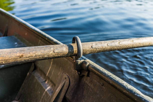 istock Row boat oar lock closeup in hole during summer with water 840077720