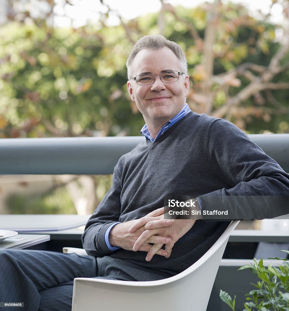 Smiling man seated at a table in a cafe  White People Stock Photo