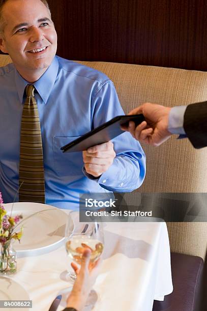 Geschäftsmann Hält Bill Im Restaurant Stockfoto und mehr Bilder von Kellnerberuf - Kellnerberuf, Teller, Zwei Personen