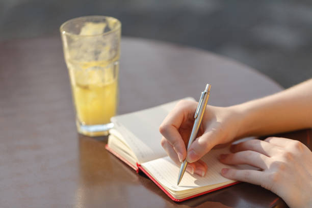 istock Young woman taking note. Writing with pen in notebook at the cafe 840088900