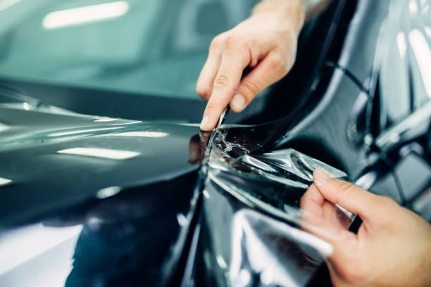 istock Worker hands installs car paint protection film 840089058