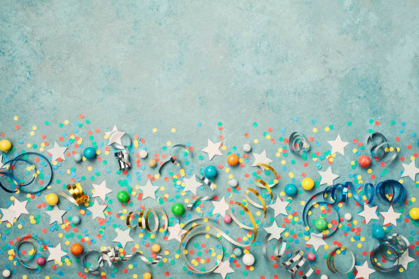 istock Holiday background decorated colorful confetti, star, candy and streamer on blue vintage table top view. Flat lay style. 840091824