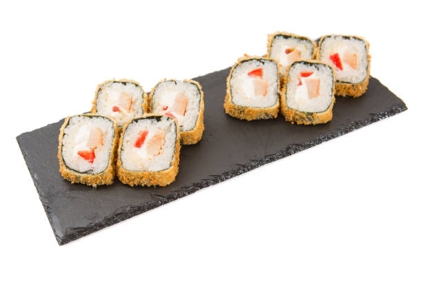 istock Fried Rolls with cheese and fried fish on black slate or stone shale surface on white background 840095814