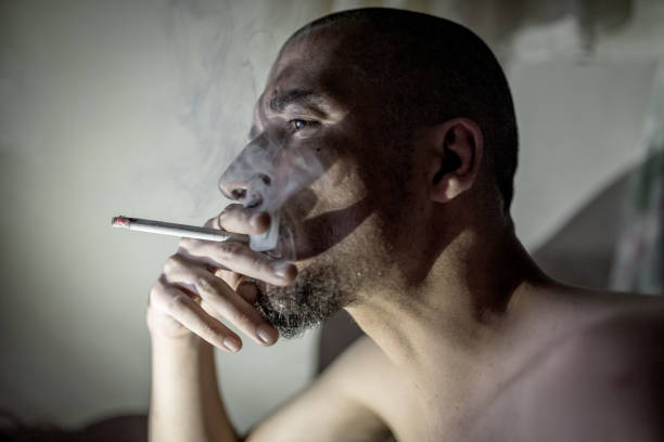 istock Young adult man smoking in dark room. 840096054