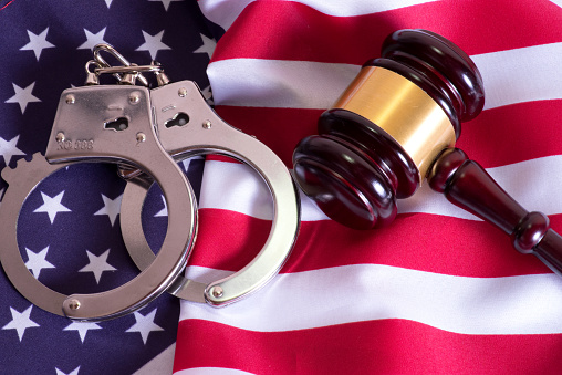 A judge's hammer, handcuffs and the American flag