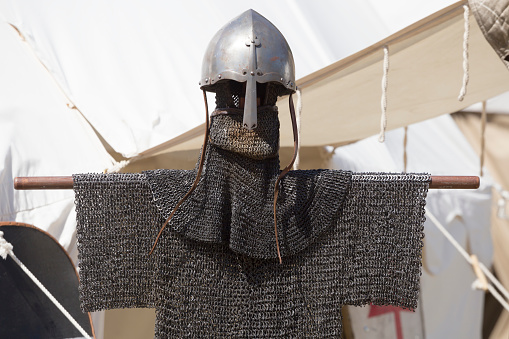 Costumed participants celebrate the Middle Ages in a recreation of a grand festival, wearing protective armour and helmets made from chain mail.