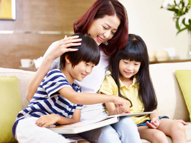 istock asian mother and two children reading book together 840109382