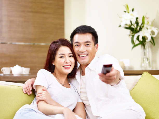 istock asian couple watching TV at home 840109462