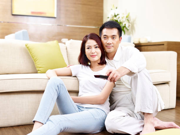 istock asian couple watching TV together 840110132