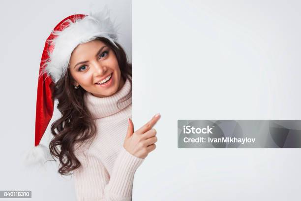 Santa Frau Zeigt Auf Leere Weiße Tafel Stockfoto und mehr Bilder von Frauen - Frauen, Weihnachtsmütze, Schönheit