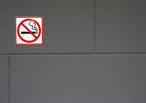 istock No smoking sign on the grey brick wall. 840124308