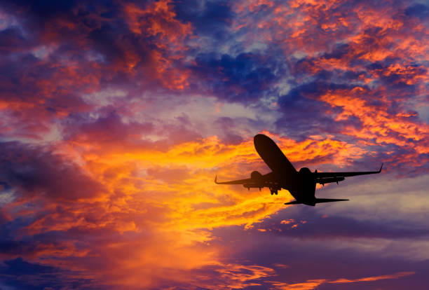 istock Silhouette passenger airplane flying away in to sky during sunset 840131646