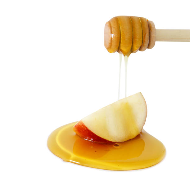 istock honey dripping on apple isolated on a white. Rosh hashanah (jewish New Year holiday) concept 840147308