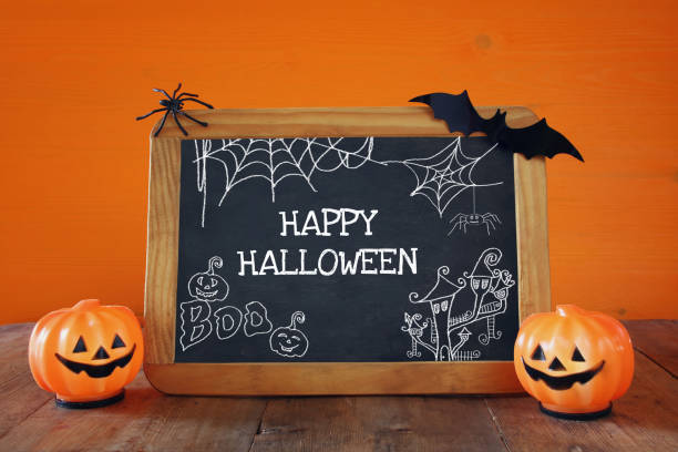 istock Cute pumpkins next to blackboard on wooden table 840147380