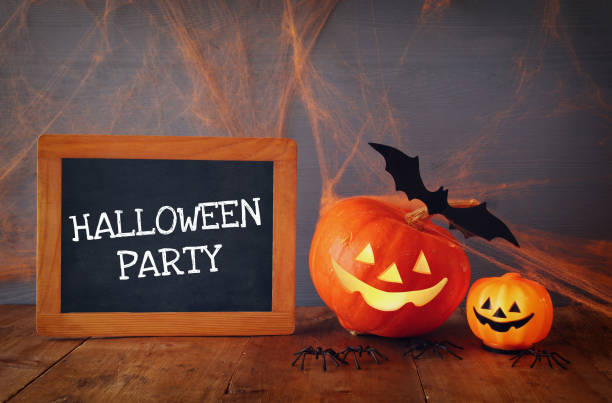 istock Cute pumpkins next to blackboard on wooden table 840147472
