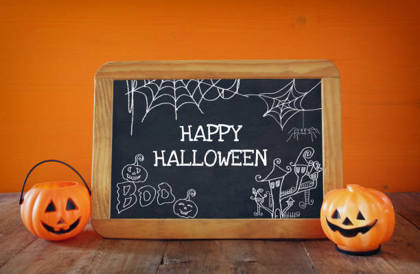 istock Cute pumpkins next to blackboard on wooden table 840147544