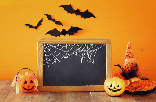 istock Halloween concept. Cute pumpkins next to blank blackboard 840147594
