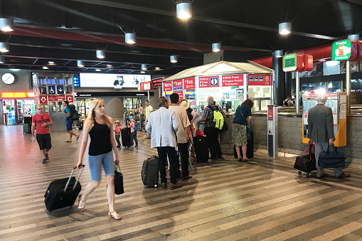 Budapest, Hungary - July 4, 2019: Passengers waiting for their train announcement standing below the departure board at end of platform