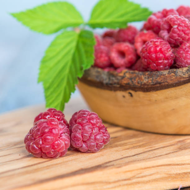 istock wild raspberry with leaves on wooden background 840154236