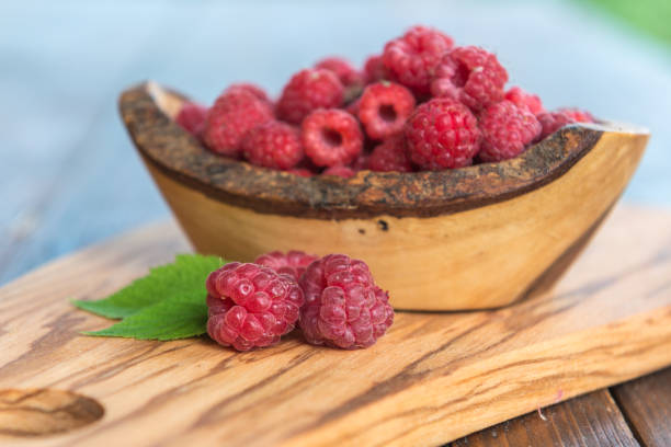 istock wild raspberry with leaves on wooden background 840154240