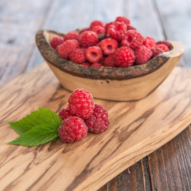 istock wild raspberry with leaves on wooden background 840154252