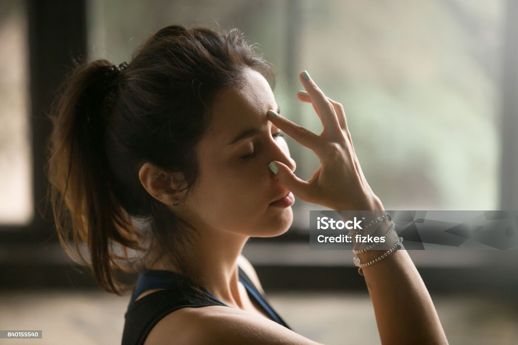 Jeune femme séduisante dans l’autre narine respirer, fond studio - Photo de Inhaler libre de droits