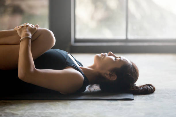 istock Young attractive woman in Apanasana pose, studio background 840157706