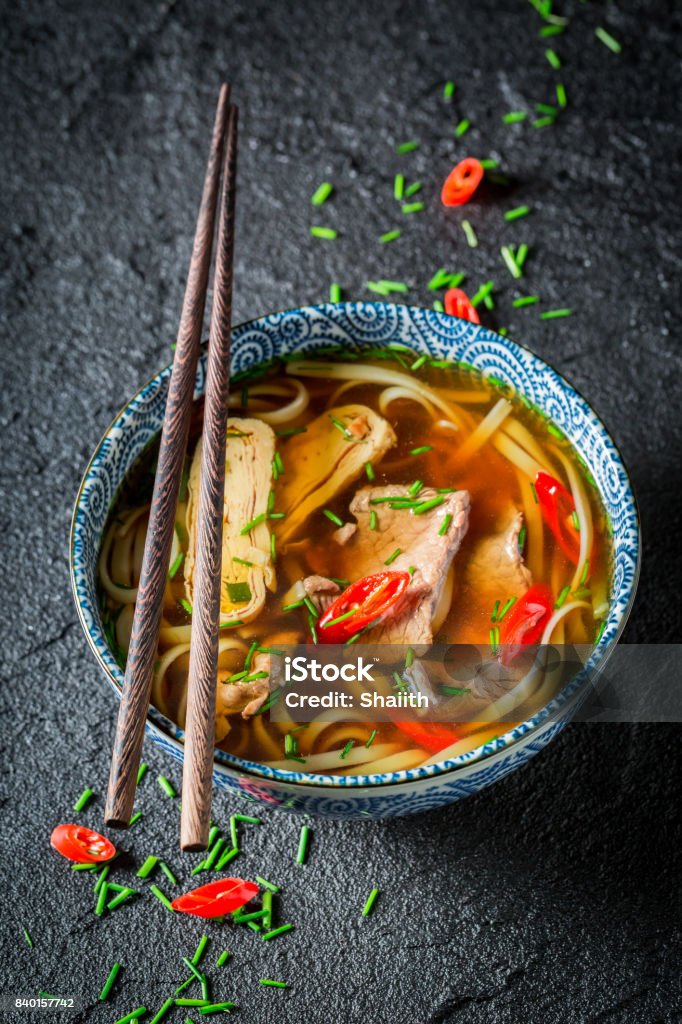 Hot Thai broth with beef and noodle on black rock Asian Food Stock Photo