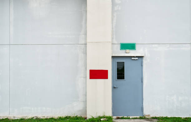 istock Closed grey door with green and red text box on white concrete wall with copy space 840158020