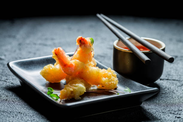 istock Hot shrimp in tempura with red sauce on black rock 840158190