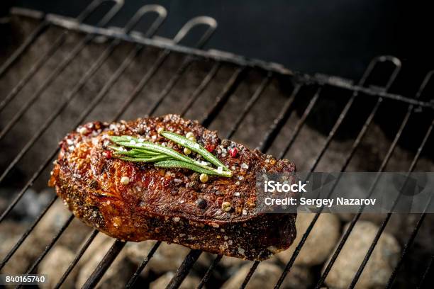 Hot Spicy Steak Grilling On A Summer Barbecue Over The Hot Coals Garnished Decorated With A Branch Of Rosemary Stock Photo - Download Image Now