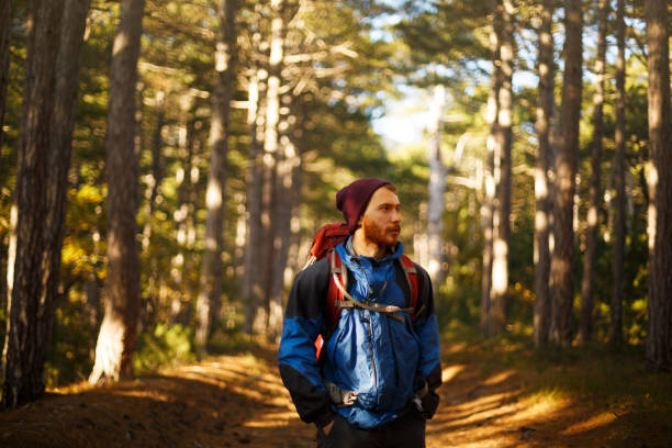istock Bearded hiker man walks in a pine yellow autumn forest. Backpacker hipster enjoys fall landscape 840167330