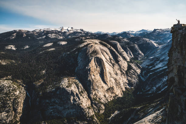istock Tiny figure on top of Half Dome raising her arm. 840167370