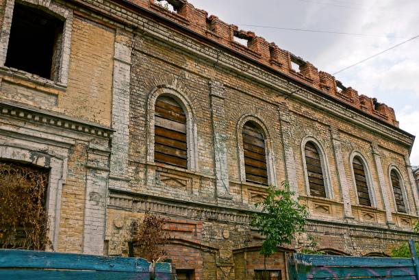 istock Old destroyed house of brown brick with boarded up windows 840184824