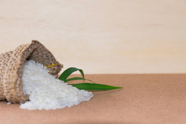 istock Thai fragrant jasmine rice on wood with gold spike on Sack. 840187800