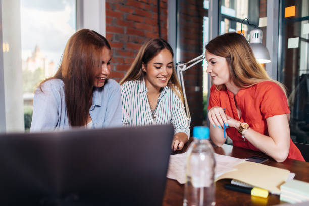istock Three smiling female college students working on project together in classroom 840209478