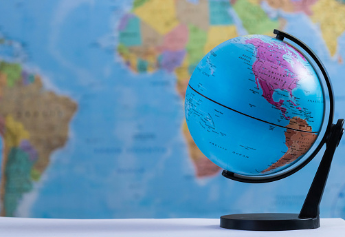 an earth globe with a blurred world map background