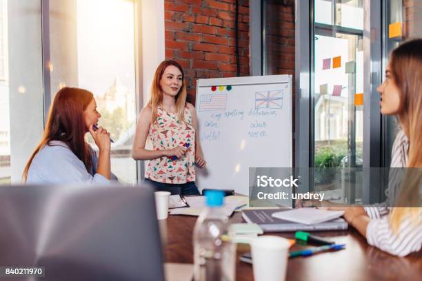 Joven Enseñando A Inglés A Adultos En La Escuela Foto de stock y más banco de imágenes de Aprender - Aprender, Inglés, Educación