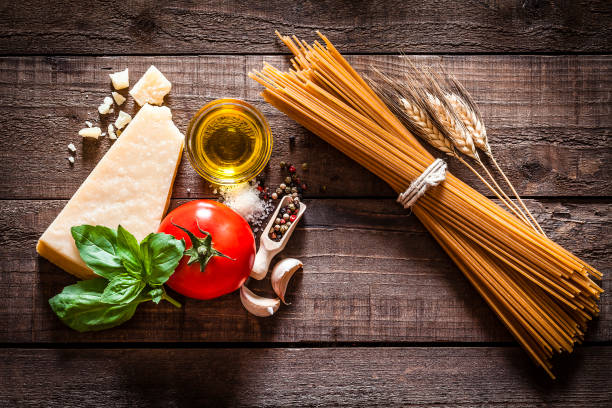 spaghetti integrali con ingredienti su tavolo rustico in legno - pasta whole wheat spaghetti raw foto e immagini stock