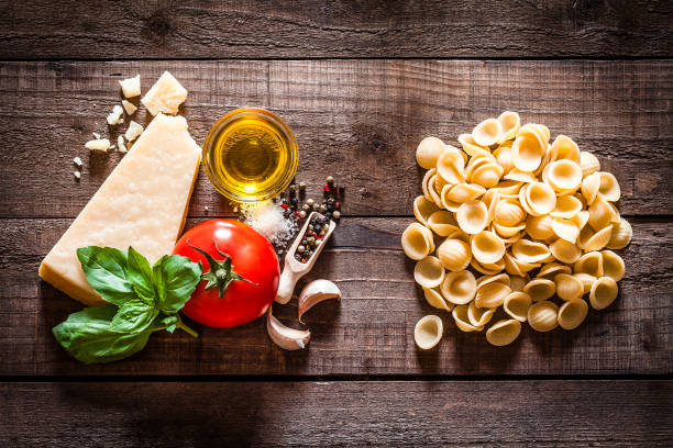 orecchiette nudeln mit zutaten auf rustikalen holztisch - orecchiette stock-fotos und bilder