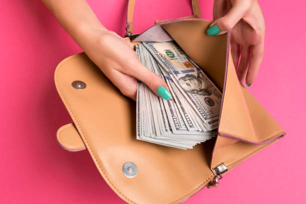 istock Woman's hand removing money from little bag, studio shot 840216650