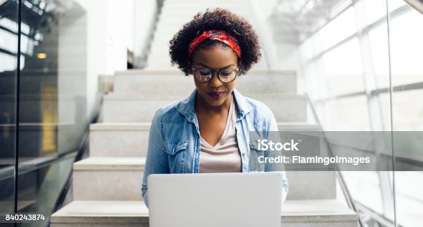 Konzentrierte Sich Jungen Afrikanischen Studenten Sitzen Auf Treppen Mit Einem Laptop Stockfoto und mehr Bilder von Frauen